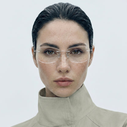 Model wearing O'S OPTICAL Stow Silver titanium rimless prescription glasses